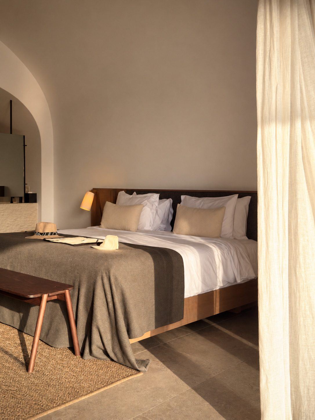 Un dormitorio sereno con luz de tarde, una cama tendida y un libro abierto.
